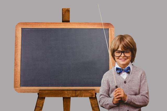 Digital composite of Portrait of smiling boy standing by blackboard against gray background