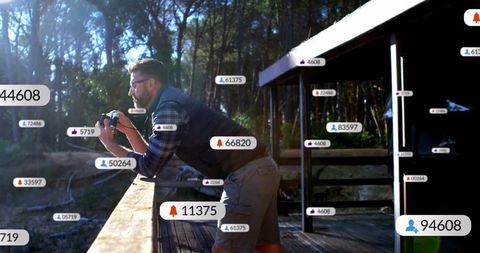 Man Exploring Nature with Camera on Rustic Cabin Deck