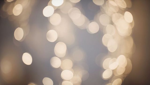 Warm golden bokeh lights creating soft glowing holiday background and twinkling ambience