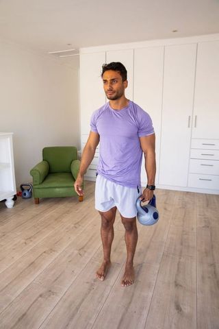 Man Holding Kettlebell in Bright Home Gym
