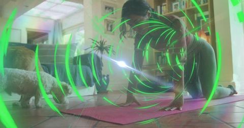 Woman stretching on pink yoga mat at home with small dog and green holographic rings