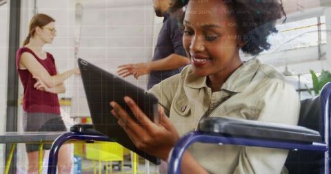 Woman using tablet in wheelchair leading inclusive office collaboration and teamwork