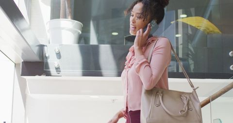 African American Businesswoman Confidently Walking and Talking on Phone in Modern Office
