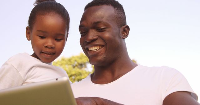 Smiling Father and Daughter Using Tablet Outdoors - Download Free Stock Images Pikwizard.com