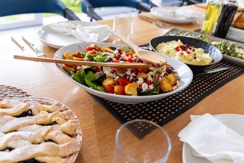 Rustic alfresco table showcasing vibrant mixed salad with wooden spoons and lattice pie