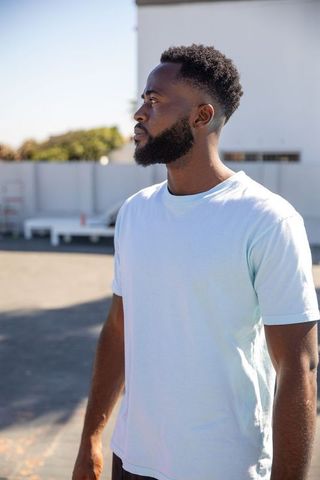 Contemplative Man Standing on Urban Rooftop with Serenity Vibes