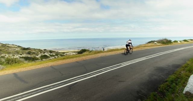 Cyclist Riding Along Ocean Coastal Highway on Sunny Day - Download Free Stock Images Pikwizard.com