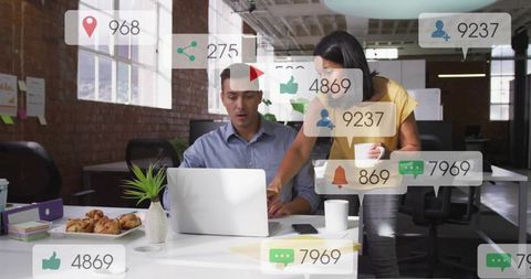 Two colleagues discussing social metrics in open office