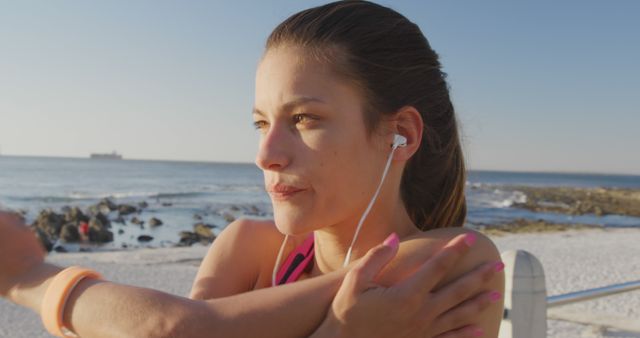 Young Woman Stretching by Ocean While Listening to Music - Download Free Stock Images Pikwizard.com