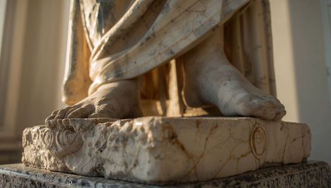Classical Marble Statue Feet with Draped Robe on Weathered Pedestal, Antique Detail