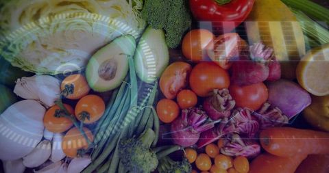 Displaying colorful vegetable flatlay with halved avocado, cherry tomatoes, glossy sheen