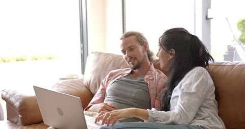 Couple Relaxing Together with Laptop on Cozy Sofa