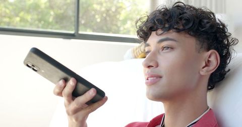 Young asian man using voice command on smartphone