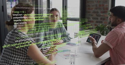 Discussing project while woman in gray blouse listening and reviewing charts, code overlay