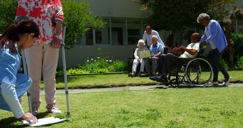 Healthcare Professional Assisting Seniors in Garden Setting
