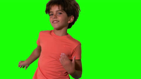 Energetic Boy Jumping Against Green Screen in Slow Motion