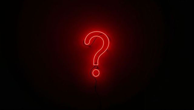 Glowing Red Neon Question Mark on Matte Black Wall with Moody Crimson Glow for Minimalist Signage