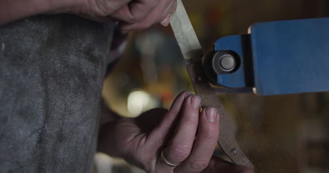 Close-up of Craftsman Sharpening Knife on Grinding Machine - Download Free Stock Images Pikwizard.com