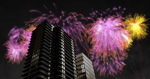 Colorful Fireworks Exploding Above Modern High-Rise Buildings