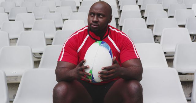 Rugby player sitting with ball in empty stadium - Download Free Stock Images Pikwizard.com