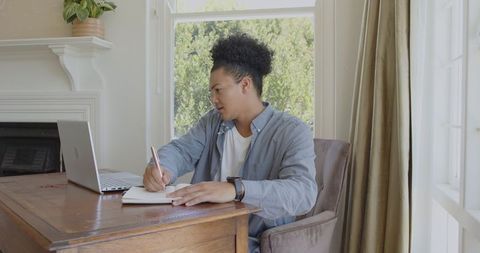 Focused Young Man Engaged in Productive Remote Work from Cozy Home Office