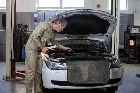 Senior Mechanic Inspecting Engine in Auto Repair Shop