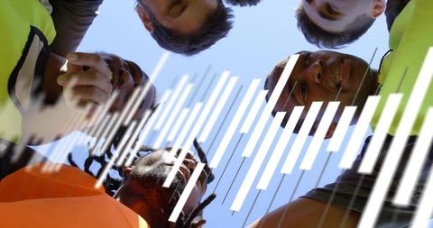 Construction crew huddling in high-visibility vests demonstrating teamwork and safety