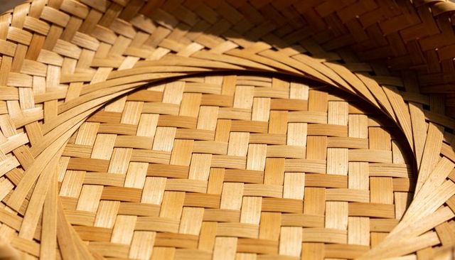 Handwoven bamboo basket showing checkerboard weave and concentric rim strips macro