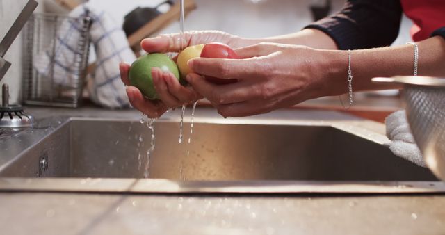 Washing Fresh Fruits Under Running Water in Kitchen Sink - Download Free Stock Images Pikwizard.com