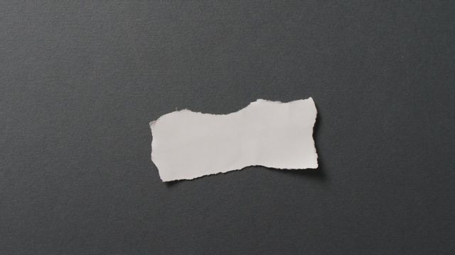 Close up view of a torn piece of white paper placed on a black background. Ideal for themes involving contrast, stationery, texture, or artistic elements. Useful for design projects, scrapbook elements, or educational materials about texture and patterns.