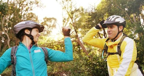Cyclists Celebrating Achievement in Sunlit Forest with Joy