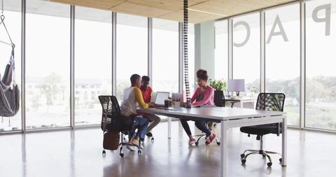 Team collaborating in modern open-plan office with hammock