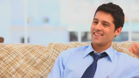 Smiling Businessman Relaxing on Sofa in Living Room