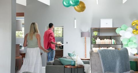 Couple tidying up living room after celebration