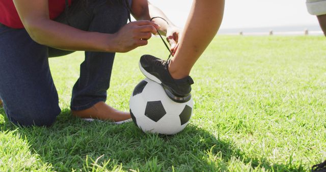Close-Up of Parent Tying Child's Soccer Shoe Outdoors - Download Free Stock Photos Pikwizard.com