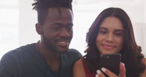 Interracial Couple Enjoying Weekend at Home with Smartphone