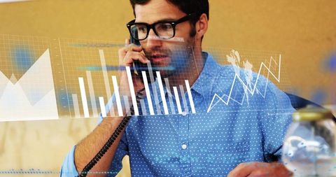 Business analyst talking on phone while analyzing interactive financial charts and data