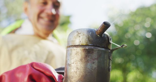 Bee Smoker Tool with Happy Beekeeper in Background on Sunny Day - Download Free Stock Images Pikwizard.com