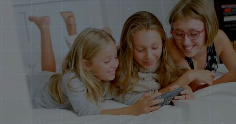 Three Siblings Watching Smartphone on Bed Smiling