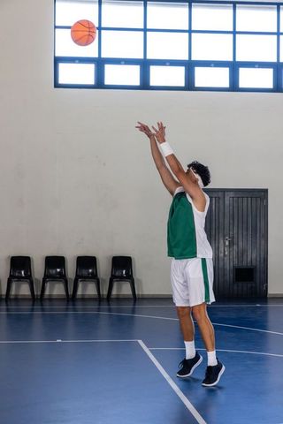 Male Basketball Player Shooting in Gym with Natural Light