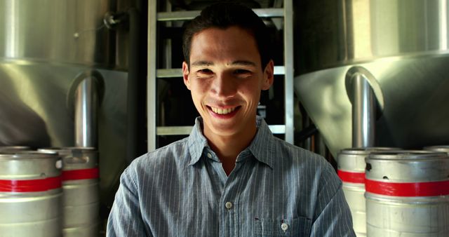 Man Smiling in Brewery with Metal Kegs - Download Free Stock Photos Pikwizard.com