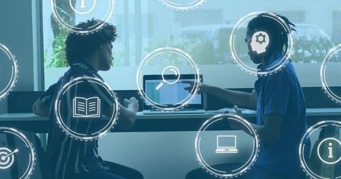 Collaborating Duo Using Laptop for Tech Study and Peer Coaching in Bright Coworking Space