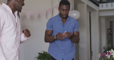 African American Friends Inflating Balloons for Celebration at Home