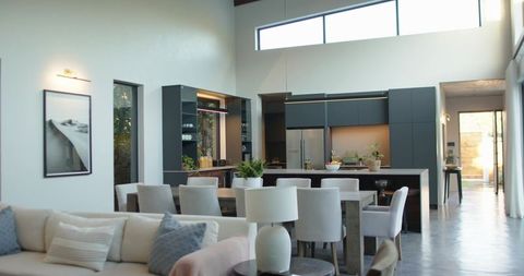 Modern Open-Plan Living Dining Space Featuring Long Dining Table, Dark Kitchen Island