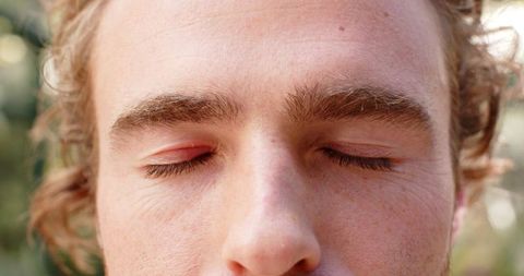 Close-up of peaceful person meditating with eyes closed outdoors