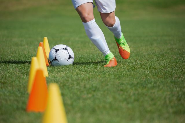 Soccer Player Dribbling Through Cones on Sunny Day - Download Free Stock Photos Pikwizard.com