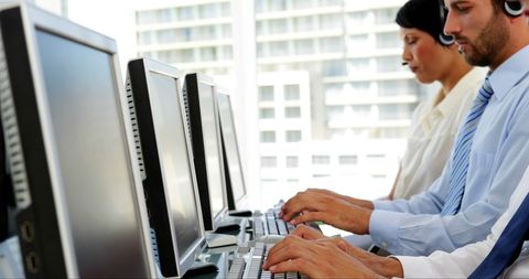 Focused Office Workers Typing at Desks in Modern Workspace - Download Free Stock Images Pikwizard.com