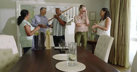 Diverse Senior Friends Celebrating with Laughter and Gifts at Home