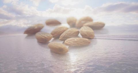 Floating almonds hovering above pastel ocean at sunrise, surreal double exposure dreamscape