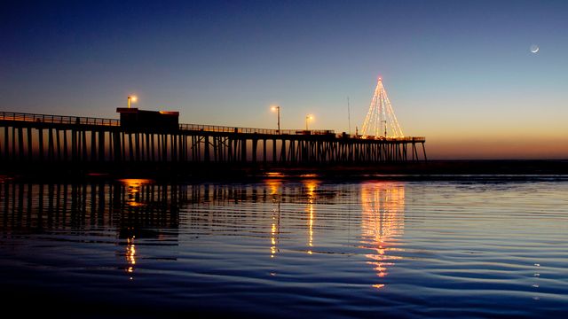 Pier Illuminated at Dusk with Festive Lights and Moon in Sky - Download Free Stock Photos Pikwizard.com